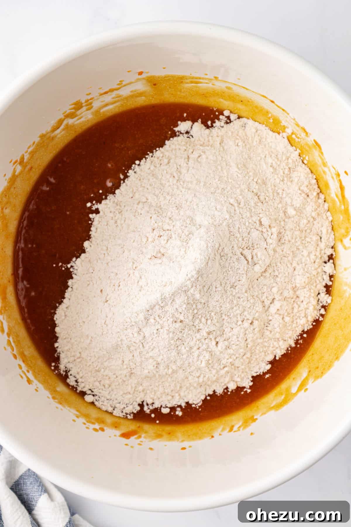 Adding dry ingredients to wet ingredients in a bowl
