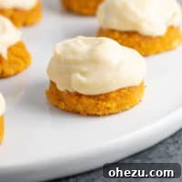 A batch of soft, spiced gluten-free pumpkin cookies with a creamy white frosting, perfect for the autumn season. These cookies are reminiscent of pumpkin pie.