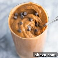A tall, frothy healthy double chocolate milkshake, garnished with chocolate shavings. Made with just five ingredients, including a secret ingredient for ultimate creaminess.