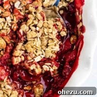 A golden-brown easy strawberry crisp, perfect for using up fresh strawberries. This delightful dessert is both gluten-free and vegan, showcasing a bubbling fruit filling.