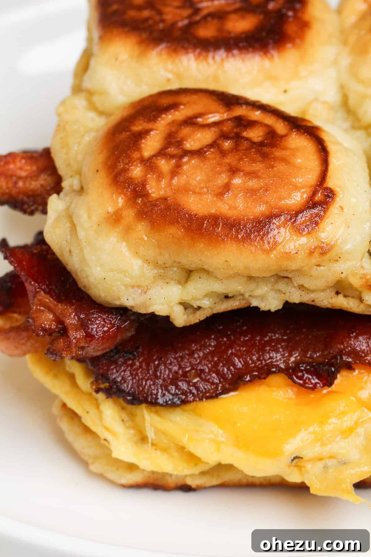 French Toast Sandwich layered with cheesy eggs and bacon, ready to eat