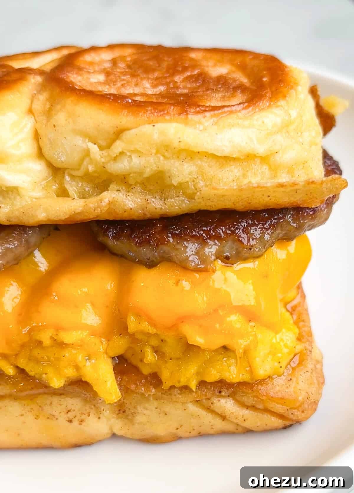 Close-up of a French Toast Sandwich on Hawaiian rolls, showcasing the fluffy eggs and bacon