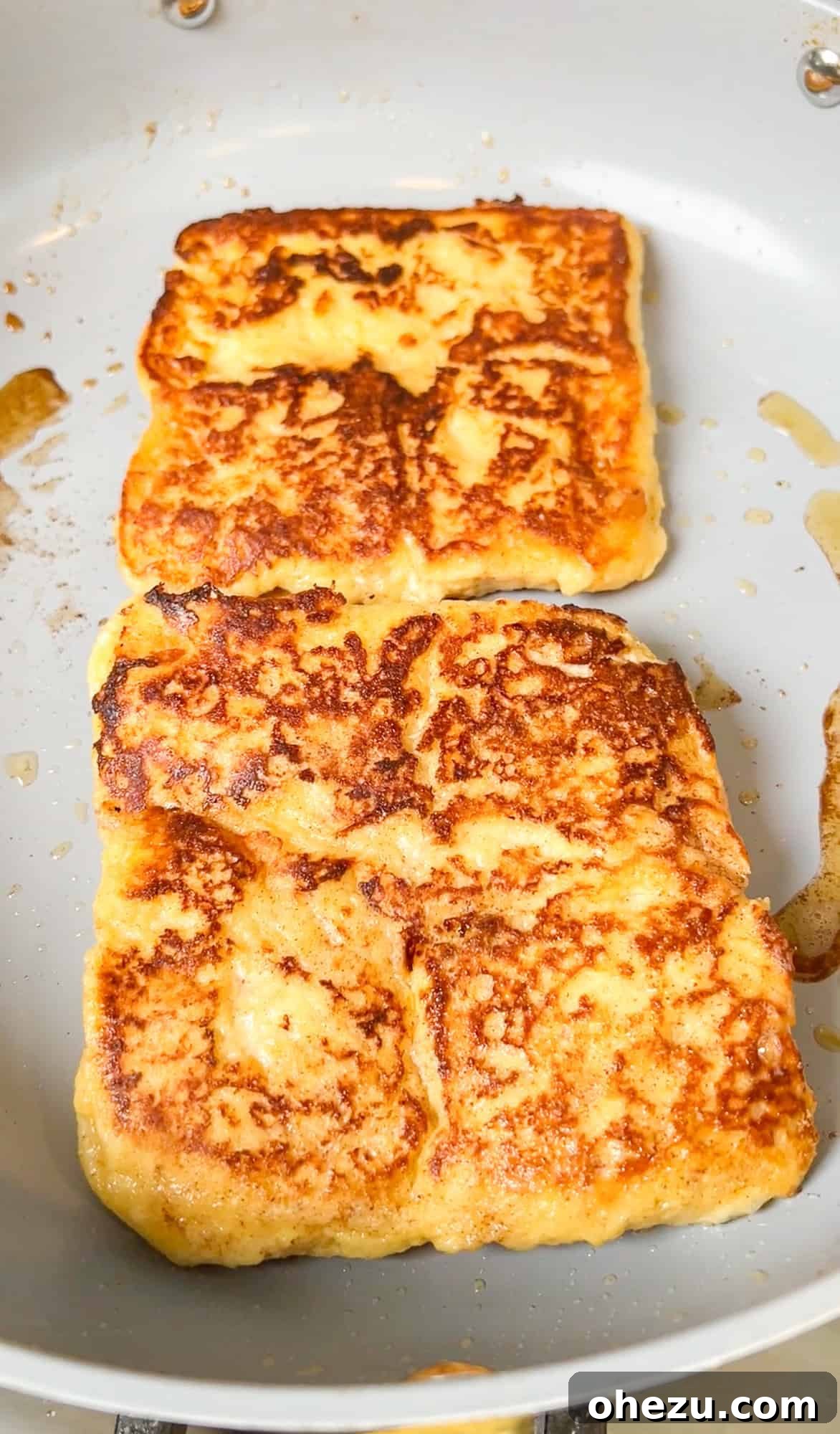 Hawaiian rolls being dipped in French toast batter and cooked in a skillet