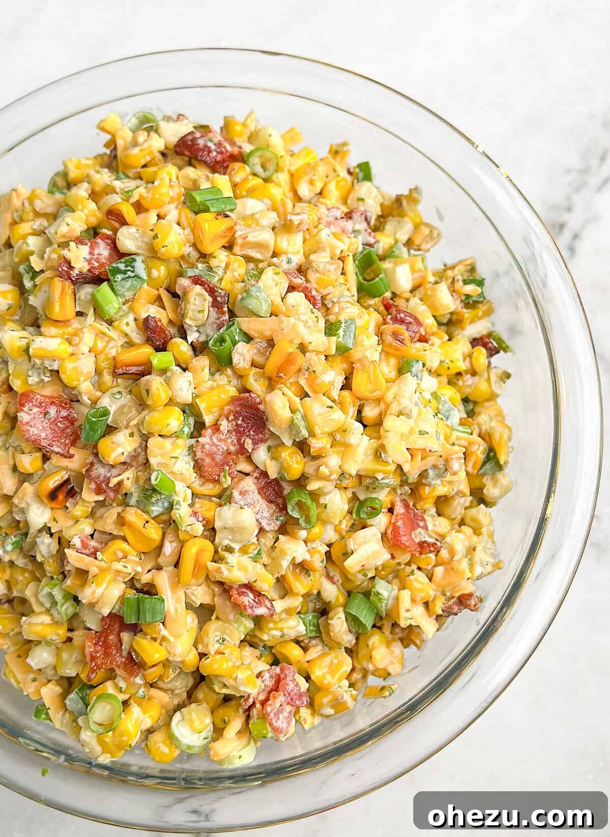 Close-up of Crack Corn Salad showcasing the textures of corn kernels, crumbled bacon, and shredded cheddar cheese.