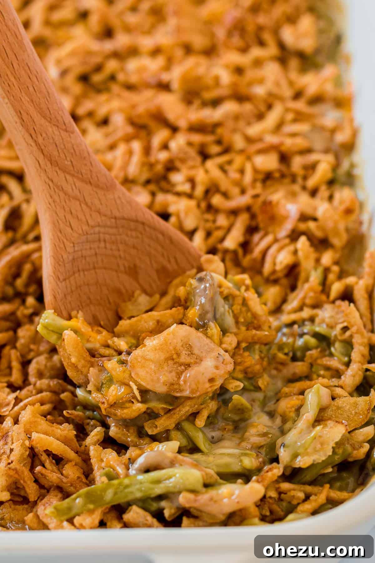 taking a scoop of green bean casserole from the dish
