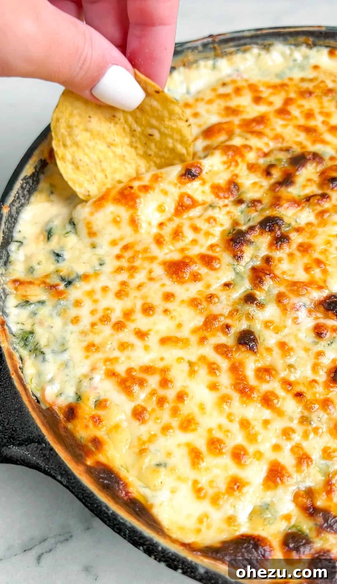 Creamy Queso Spinach Dip with melted cheese ready to be served