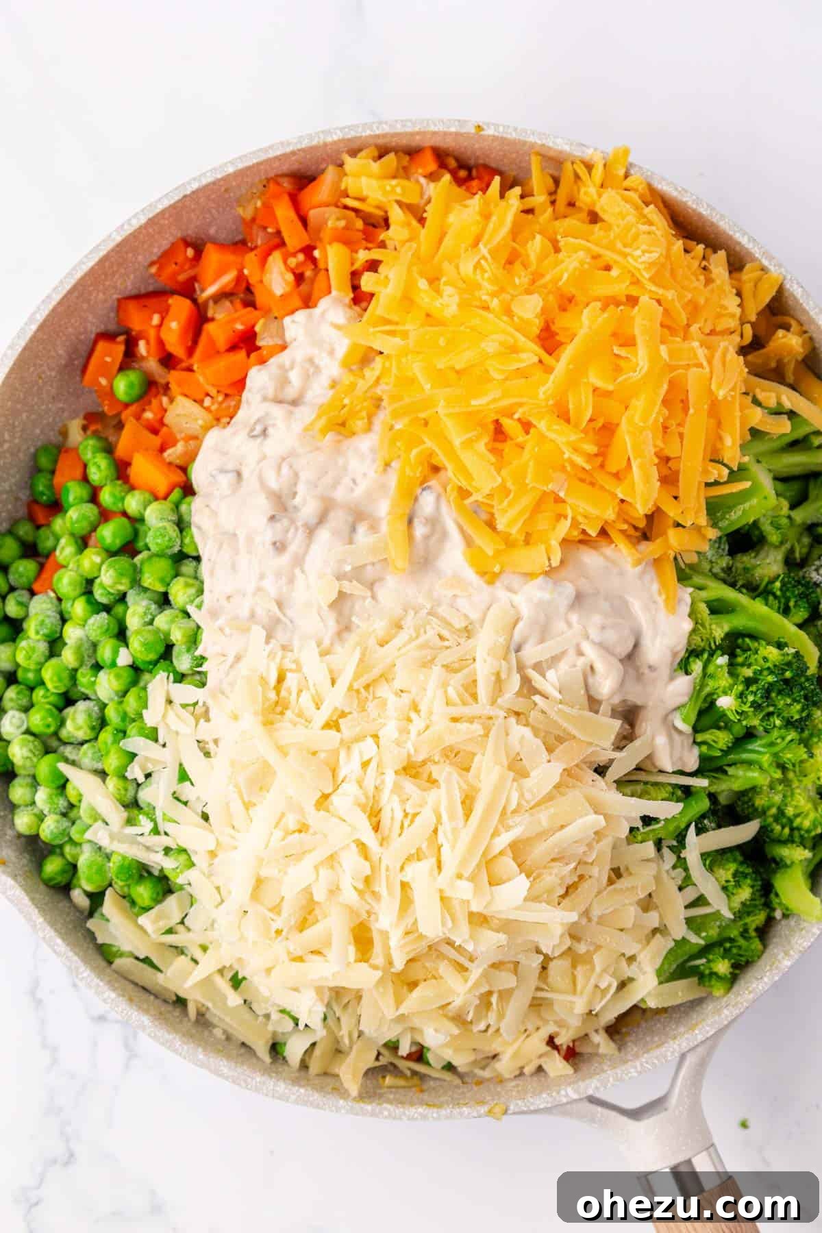 Hearty Vegetable Rice Bake 8 Cream of mushroom soup and cheese being added to the vegetable mixture in the skillet