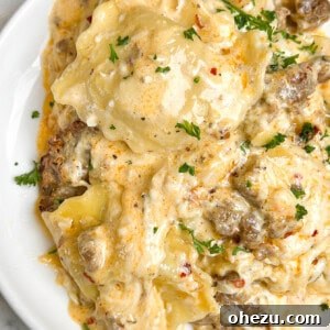 A dish of Sausage Alfredo Ravioli Lasagna, showcasing a golden crust and creamy interior.