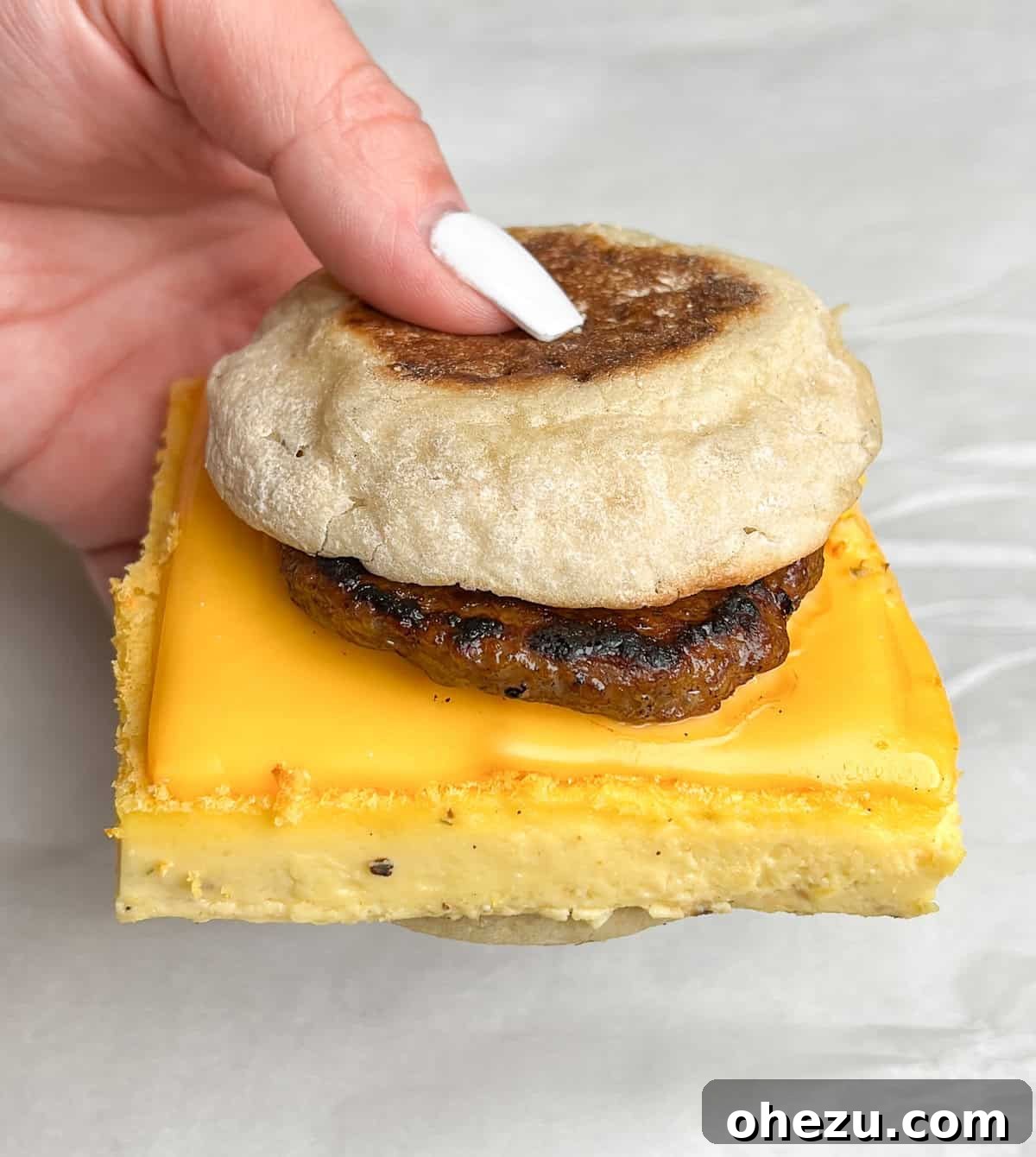 One-Pan Protein Power Breakfast Sandwiches 3 Close-up of the perfectly cooked sheet pan eggs, showcasing their delicate, custardy texture and rich yellow color, ready for slicing