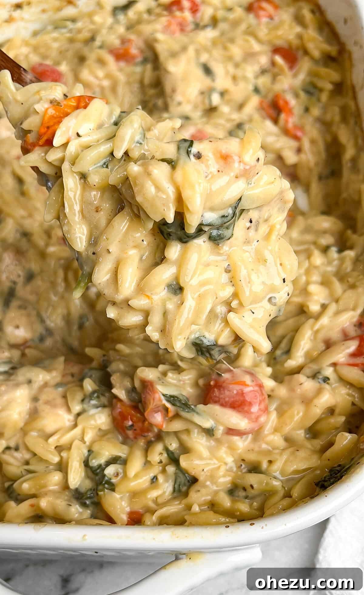 Creamy Tuscan Chicken Orzo Skillet 4 Assembling ingredients for One-Pan Tuscan Chicken Bake in a casserole dish