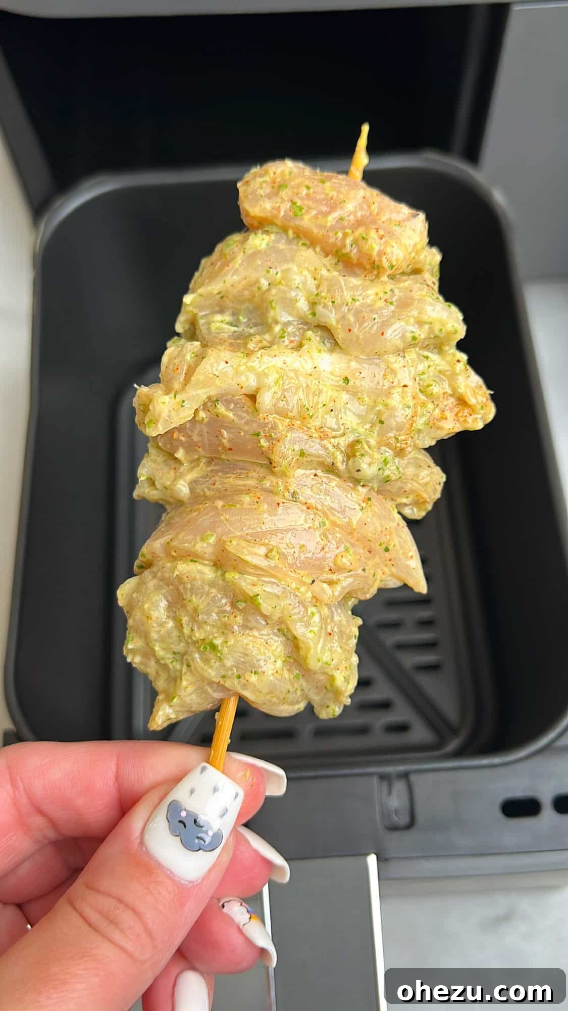 Zesty Cilantro Lime Air Fryer Chicken Skewers 6 Chicken skewers being placed into an air fryer basket, ready for cooking.