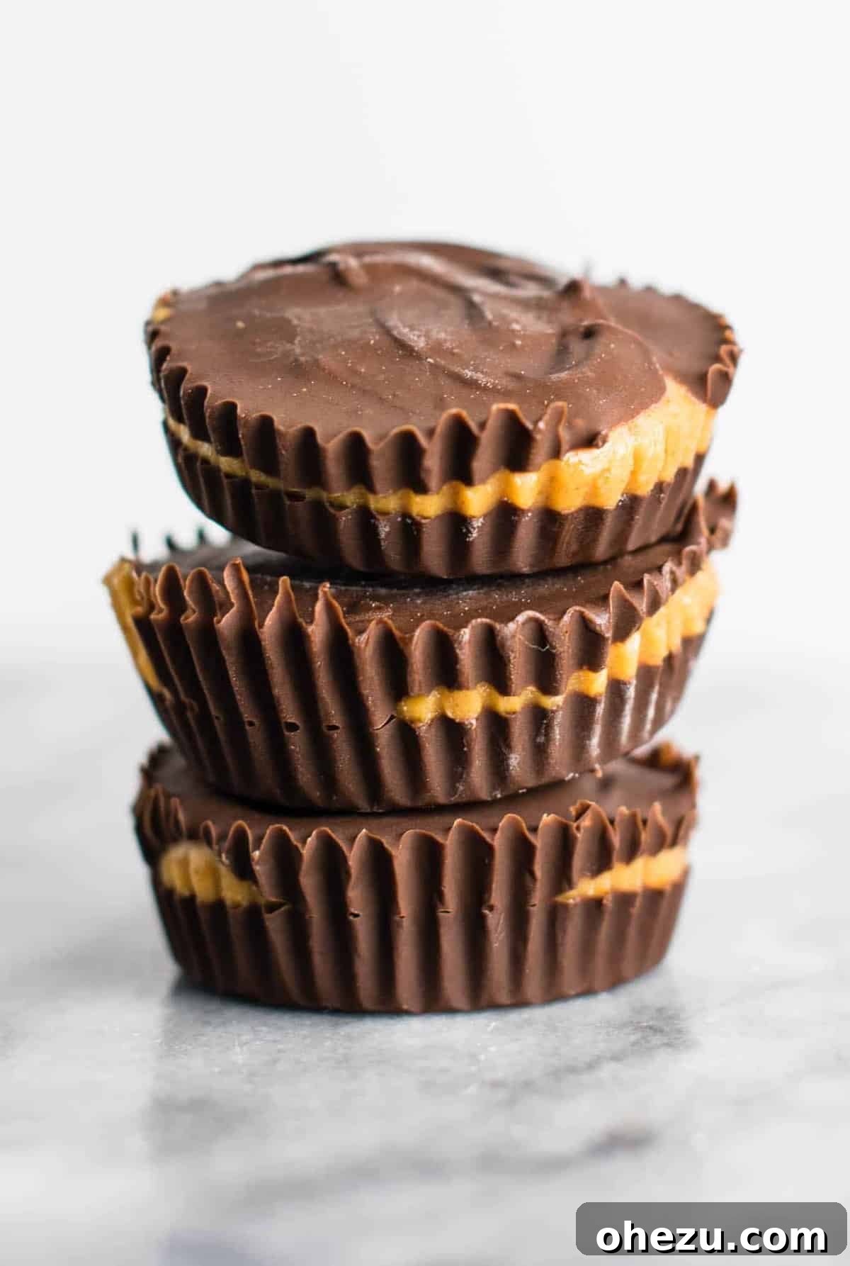 25 Must-Try Vegan Recipes for Plant-Based Perfection 11 Homemade vegan chocolate peanut butter cups, unwrapped and stacked, showing the smooth peanut butter filling.