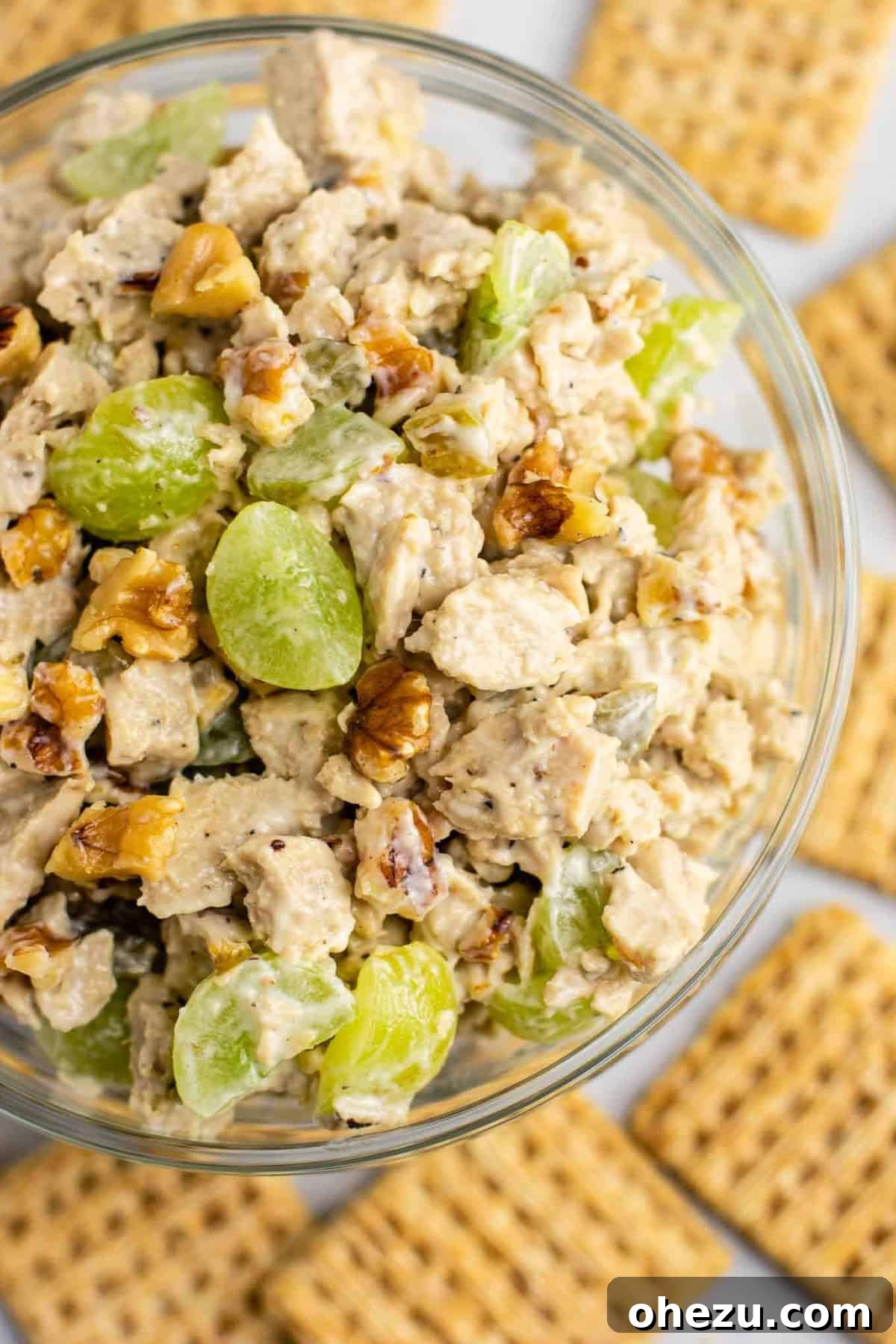 25 Must-Try Vegan Recipes for Plant-Based Perfection 13 A serving of creamy vegan chicken salad with grapes and pecans on a slice of wheat bread, on a rustic cutting board.
