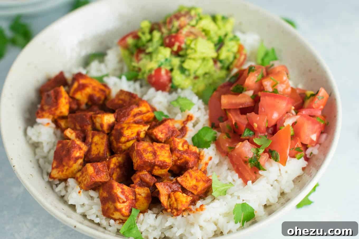 25 Must-Try Vegan Recipes for Plant-Based Perfection 24 Enchilada tofu burrito bowls with homemade guacamole and salsa, showcasing a colorful and hearty vegan meal.