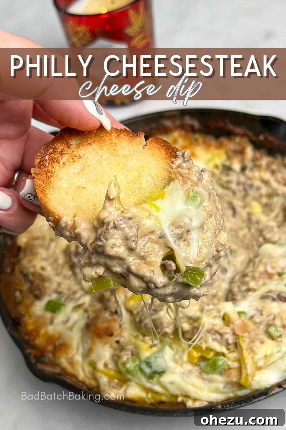 Baked Philly Cheesesteak Dip in a cast iron skillet, garnished with fresh herbs and ready to enjoy