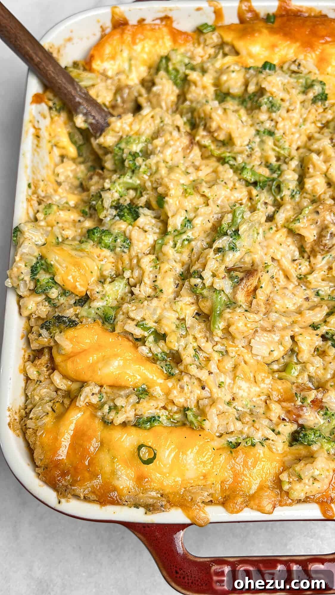 Golden Cheesy Chicken Broccoli Rice Bake 2 golden brown chicken broccoli rice casserole in a white baking dish, ready to be served