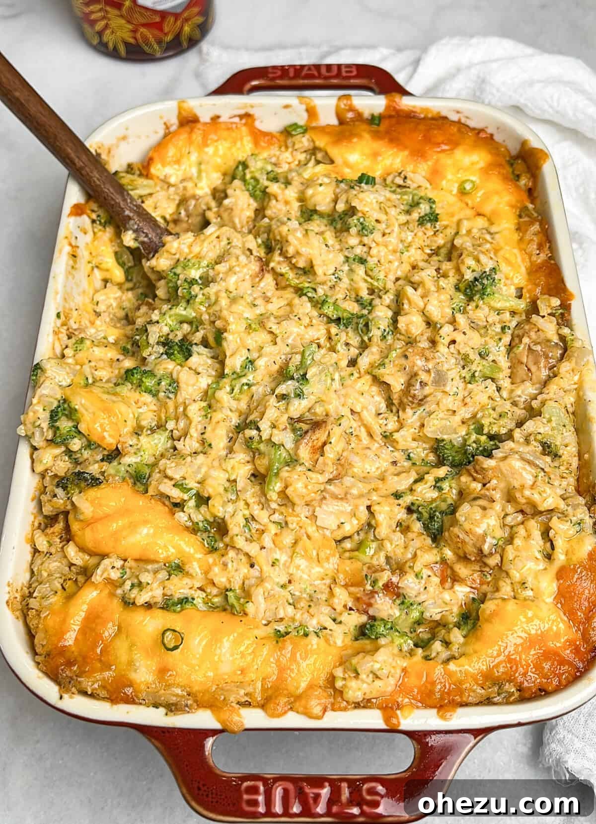 Golden Cheesy Chicken Broccoli Rice Bake 7 a fork scooping a portion of cheesy chicken broccoli rice casserole from the baking dish