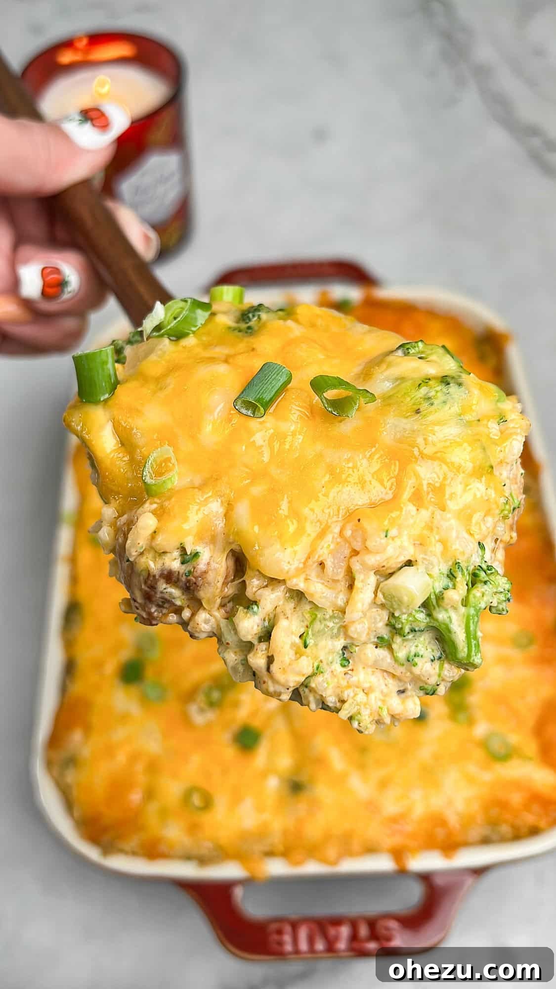 Golden Cheesy Chicken Broccoli Rice Bake 8 a serving spoon taking a portion of chicken broccoli rice casserole from a white baking dish