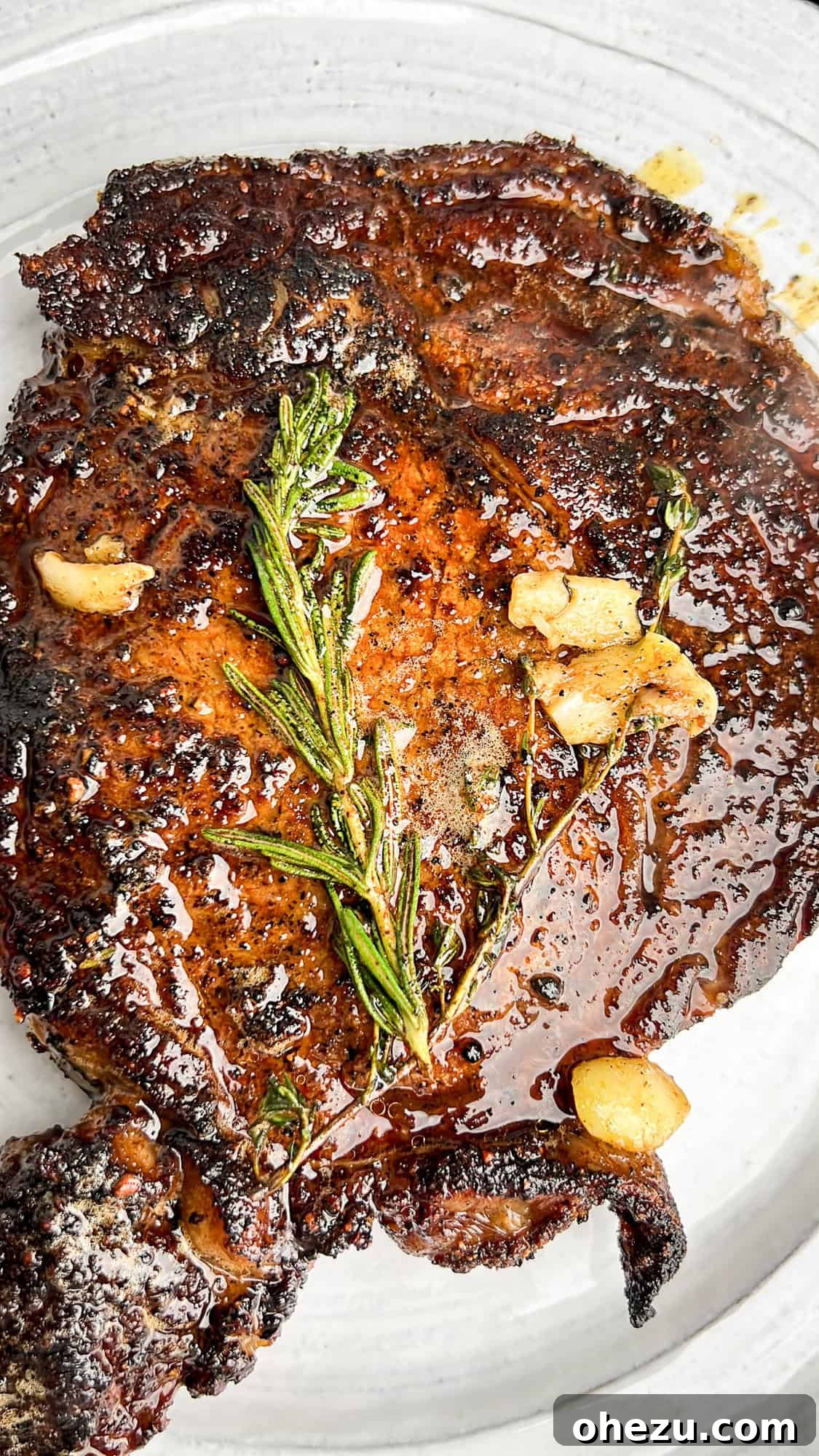 Cognac Kissed Cast Iron Steak 3 Seared steak basted with herbs and garlic in a cast iron skillet.