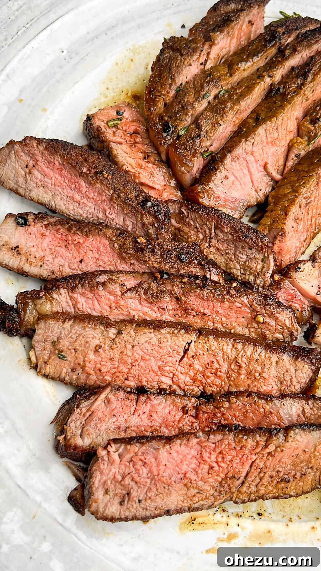 Cognac Kissed Cast Iron Steak 4 Perfectly sliced medium-rare steak on a plate, ready to be served.