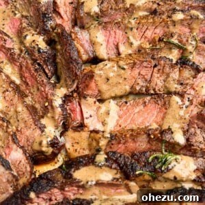 Seared steaks in a cast iron skillet with fresh herbs.