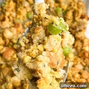A spoon holding a scoop of southern cornbread dressing up to the camera.