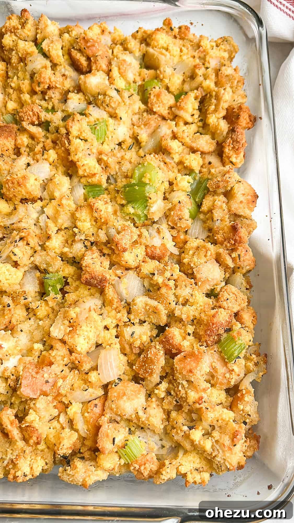 Overhead shot of a full baking dish of Southern cornbread dressing, with steam subtly rising.