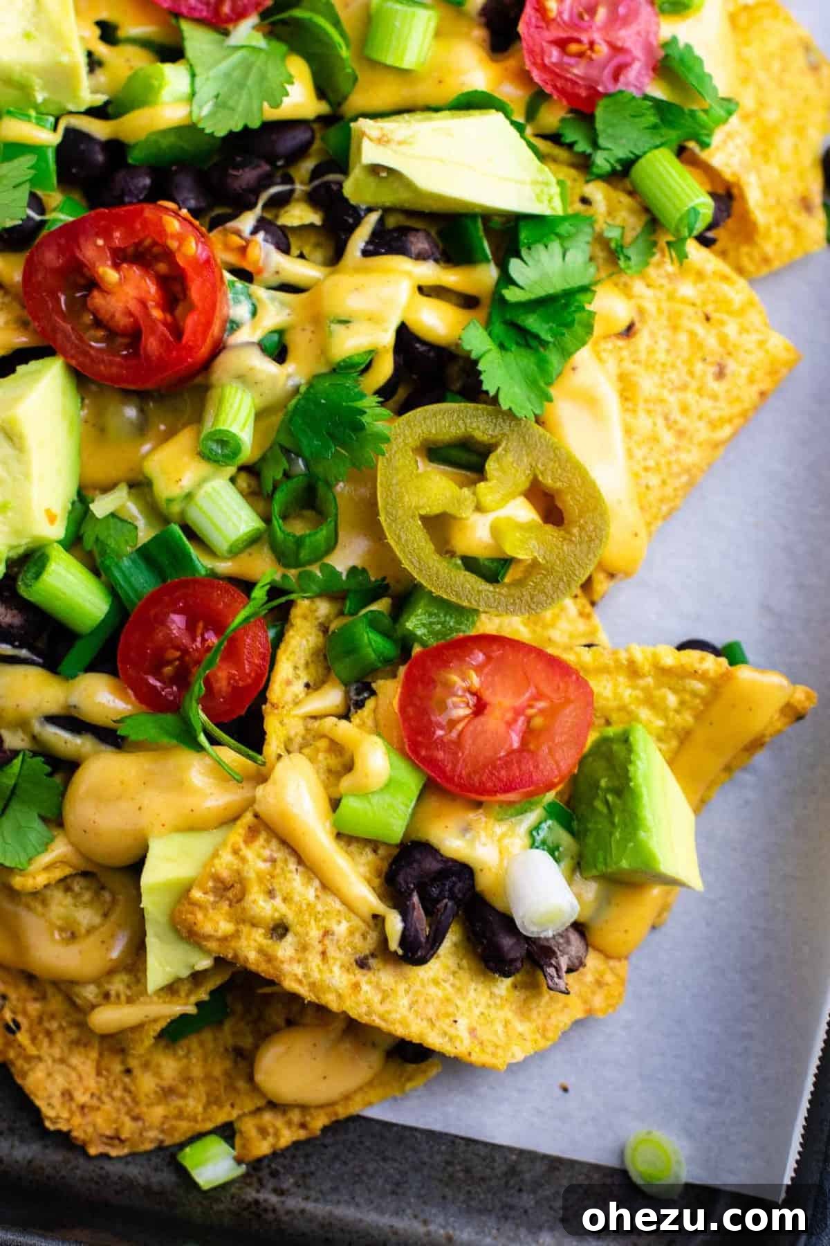 Ultimate Loaded Vegetable Nachos 2 Loaded veggie nachos generously topped with homemade nacho cheese sauce, fresh vegetables, and vibrant garnishes. This is an amazing vegetarian dish!