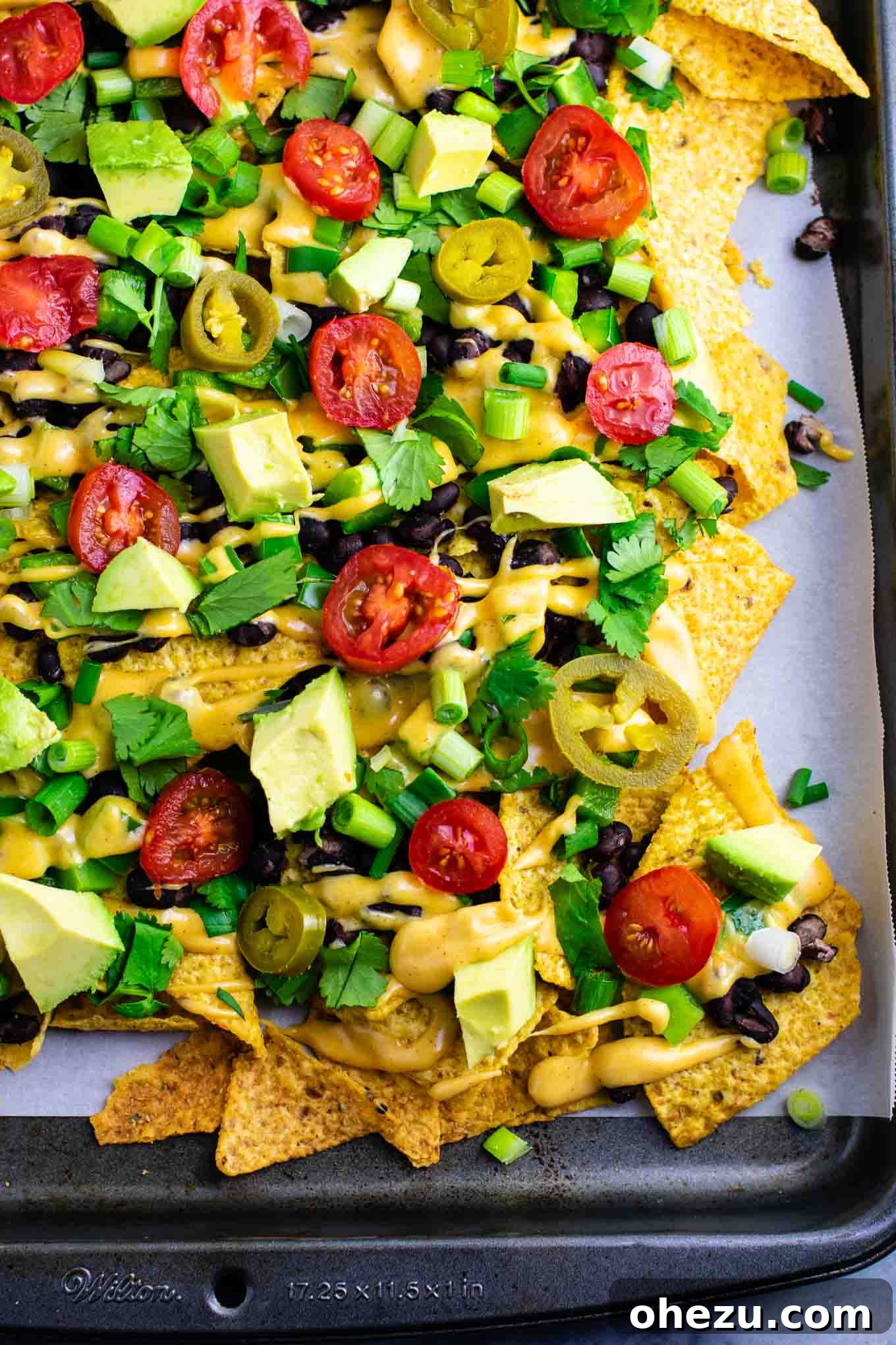 Ultimate Loaded Vegetable Nachos 4 A vibrant platter of loaded vegetarian nachos ready to be served, highlighting the fresh toppings like avocado and cilantro. #veggienachos #vegetarian #nachocheese #nachocheesesauce