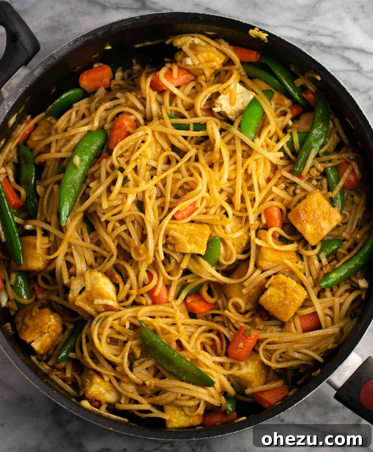 Delicious tofu stir fry noodles cooking in a large skillet