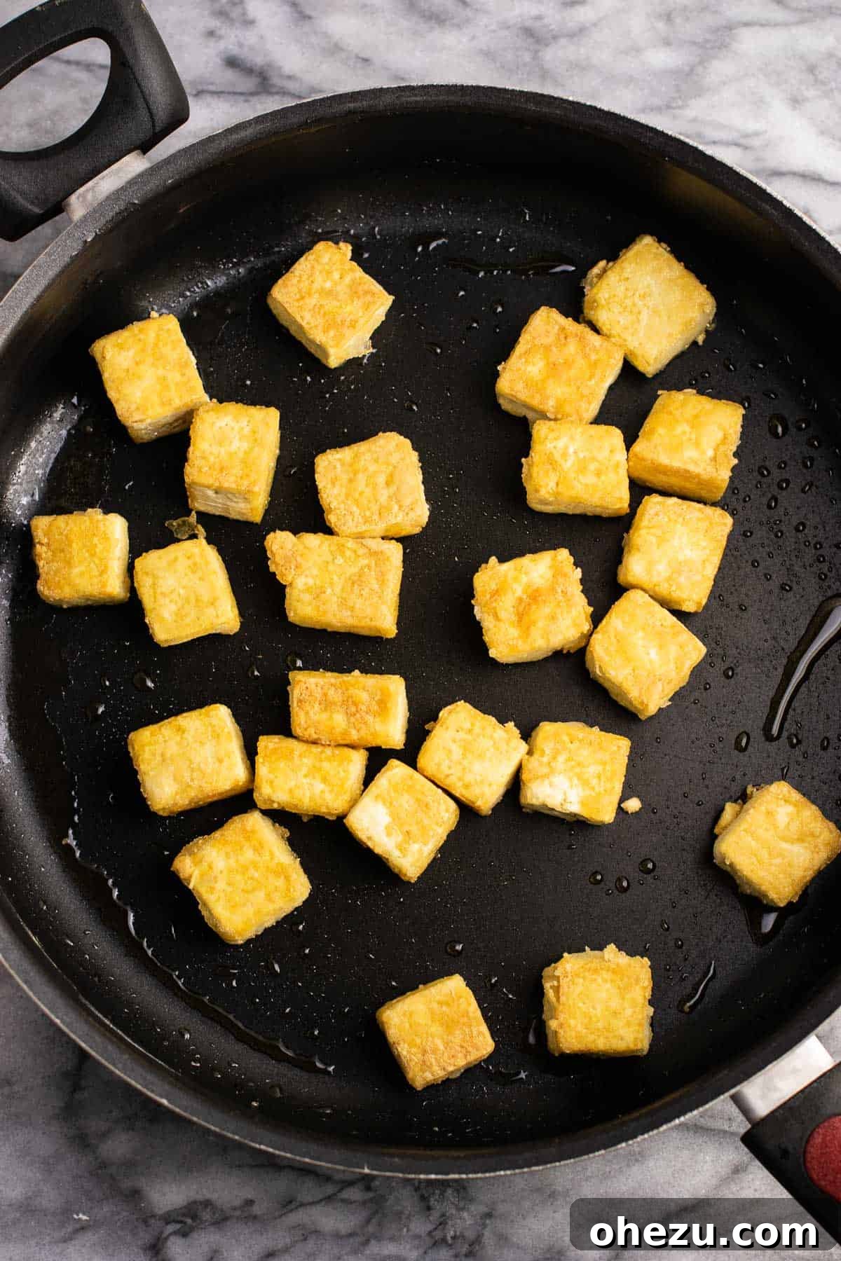 Perfectly crispy, browned tofu cubes in a skillet, ready for the next step.