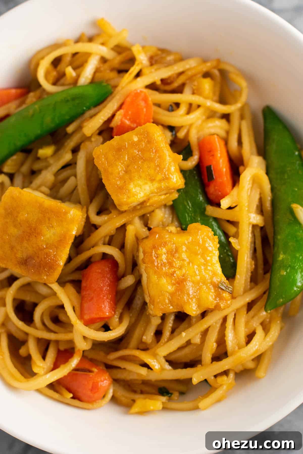 Tofu stir fry noodles portioned for meal prep in containers.