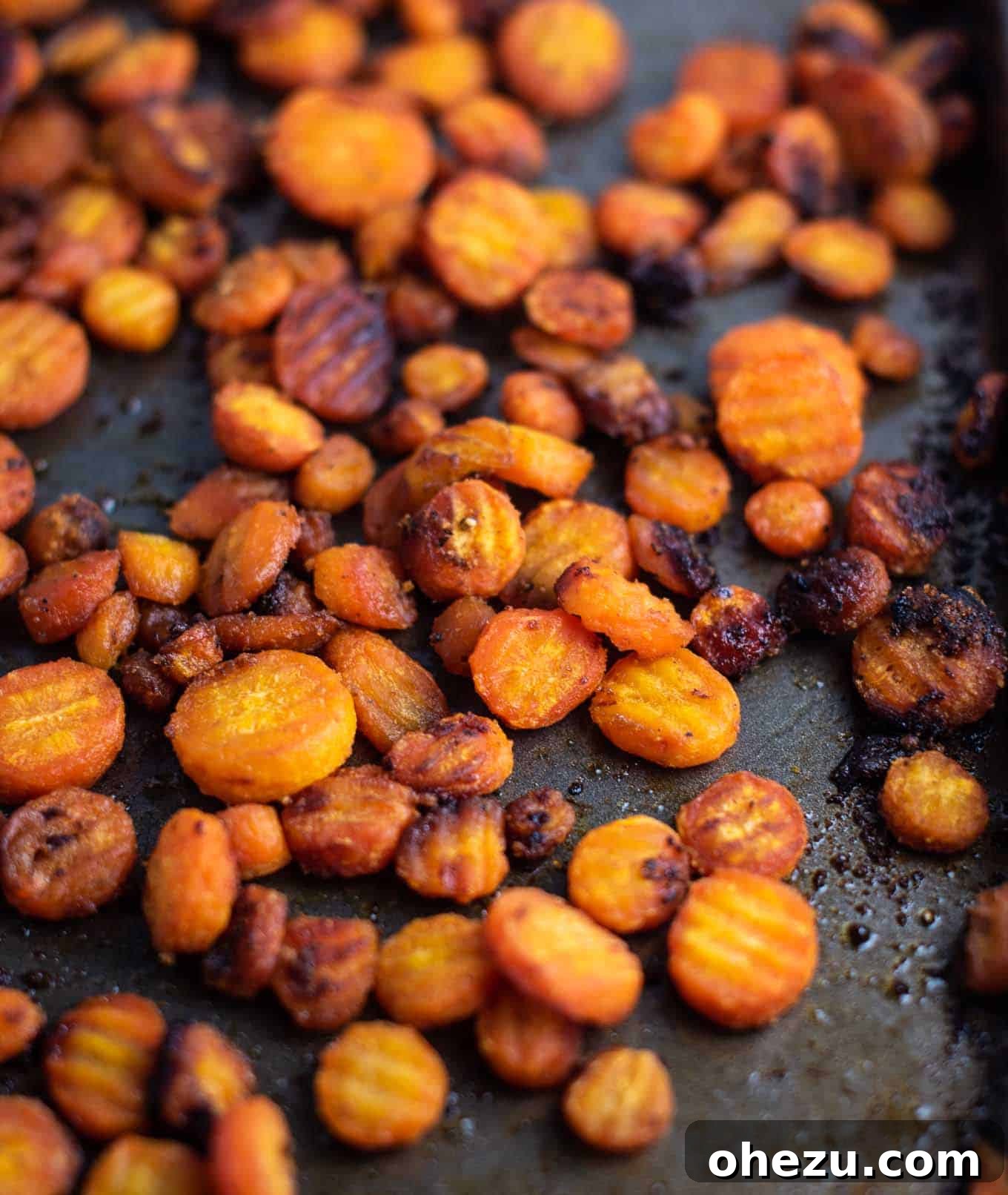 Oven-roasted crinkle-cut carrots on a baking sheet, freshly cooked and ready to serve, showing golden-brown edges.