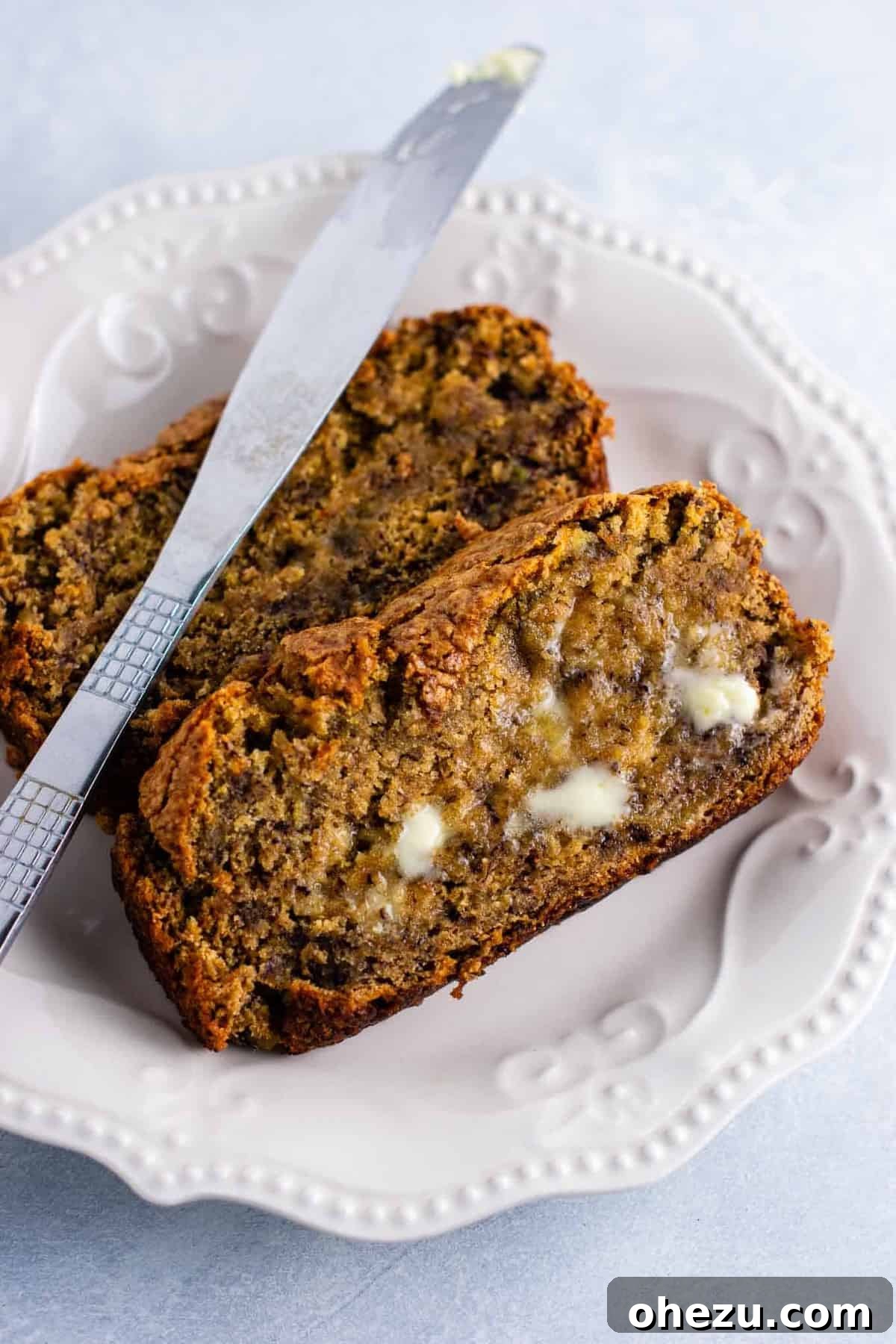 Ultimate Vegan Banana Bread 2 Deliciously moist vegan banana bread slices on a cooling rack, showing off its perfect golden crust and tender texture. A truly easy and wholesome plant-based recipe, dairy-free and egg-free.