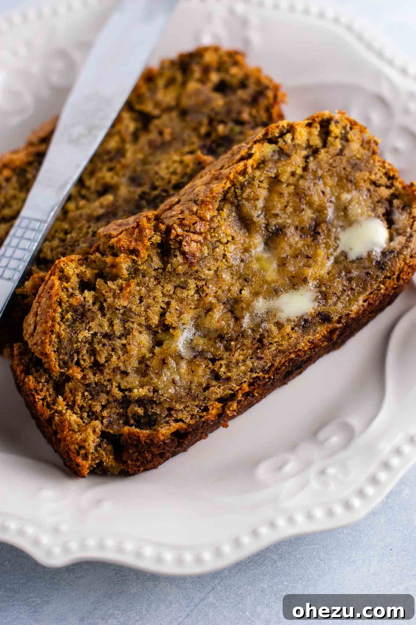 Ultimate Vegan Banana Bread 3 Close-up of a warm slice of vegan banana bread, showcasing its rich texture and inviting aroma. Perfect for a dairy-free and egg-free breakfast or snack.