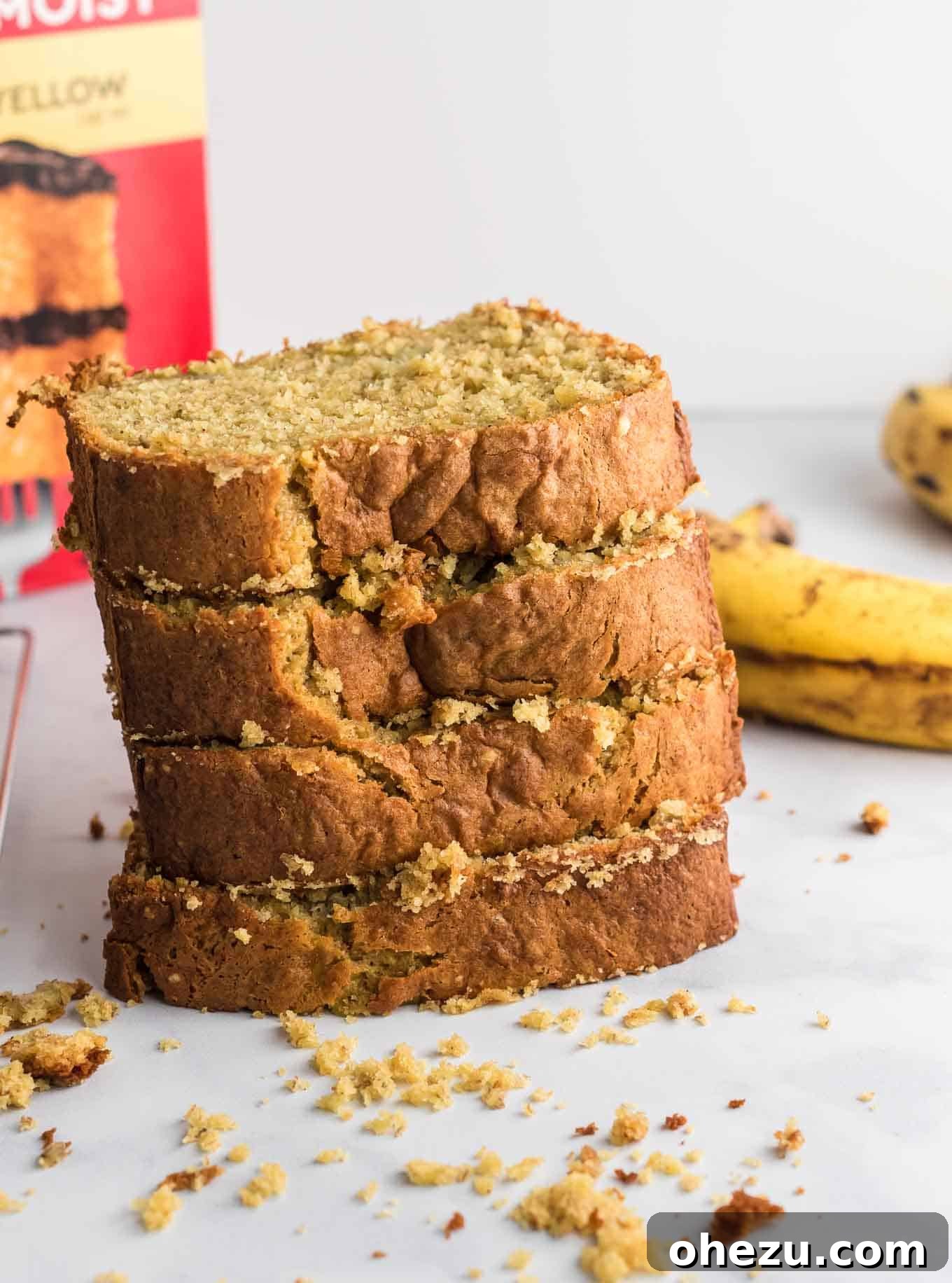 four perfectly baked slices of banana bread stacked neatly on a plate