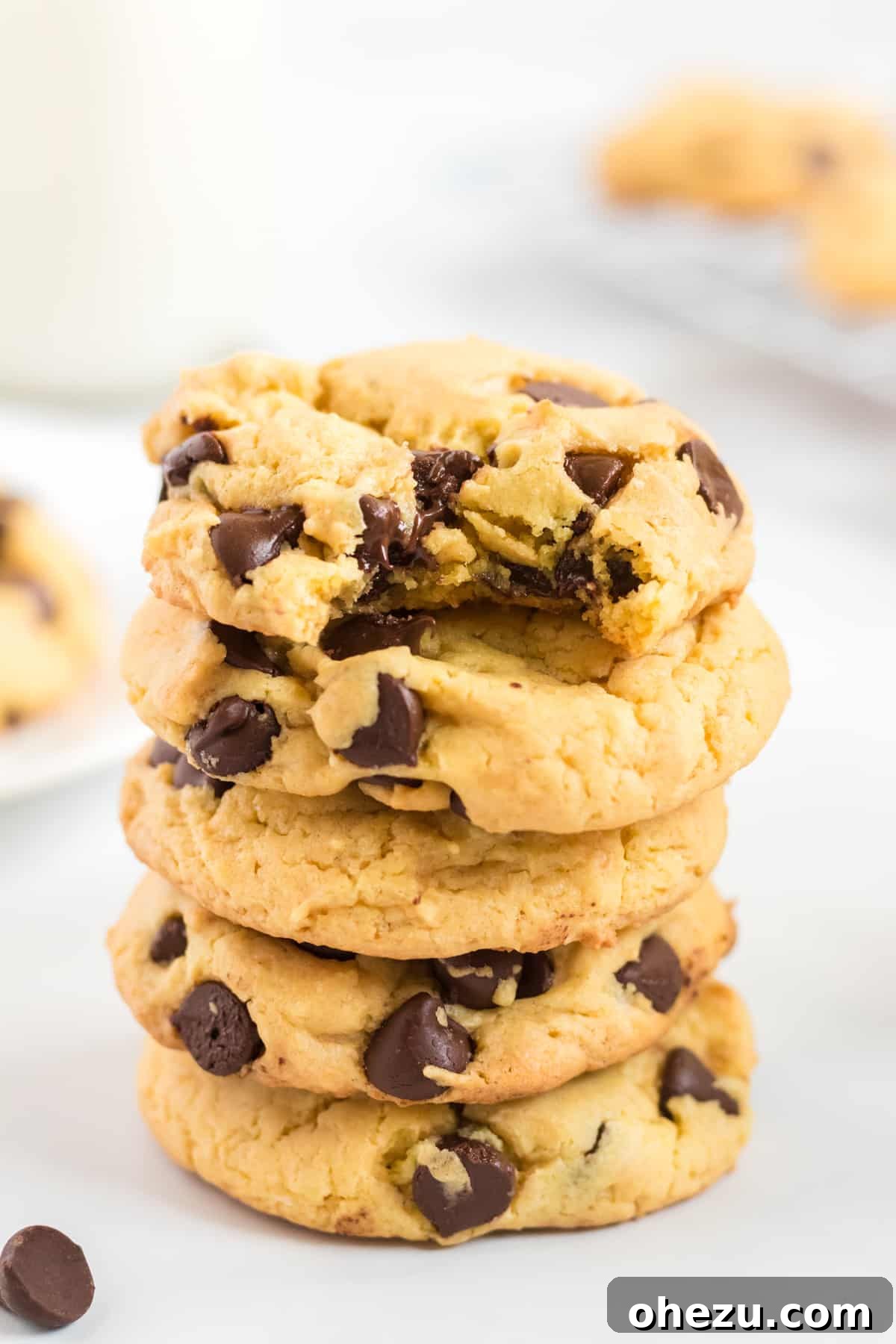 A stack of yellow cake mix cookies with the top one taken a bite out of, showing the gooey chocolate