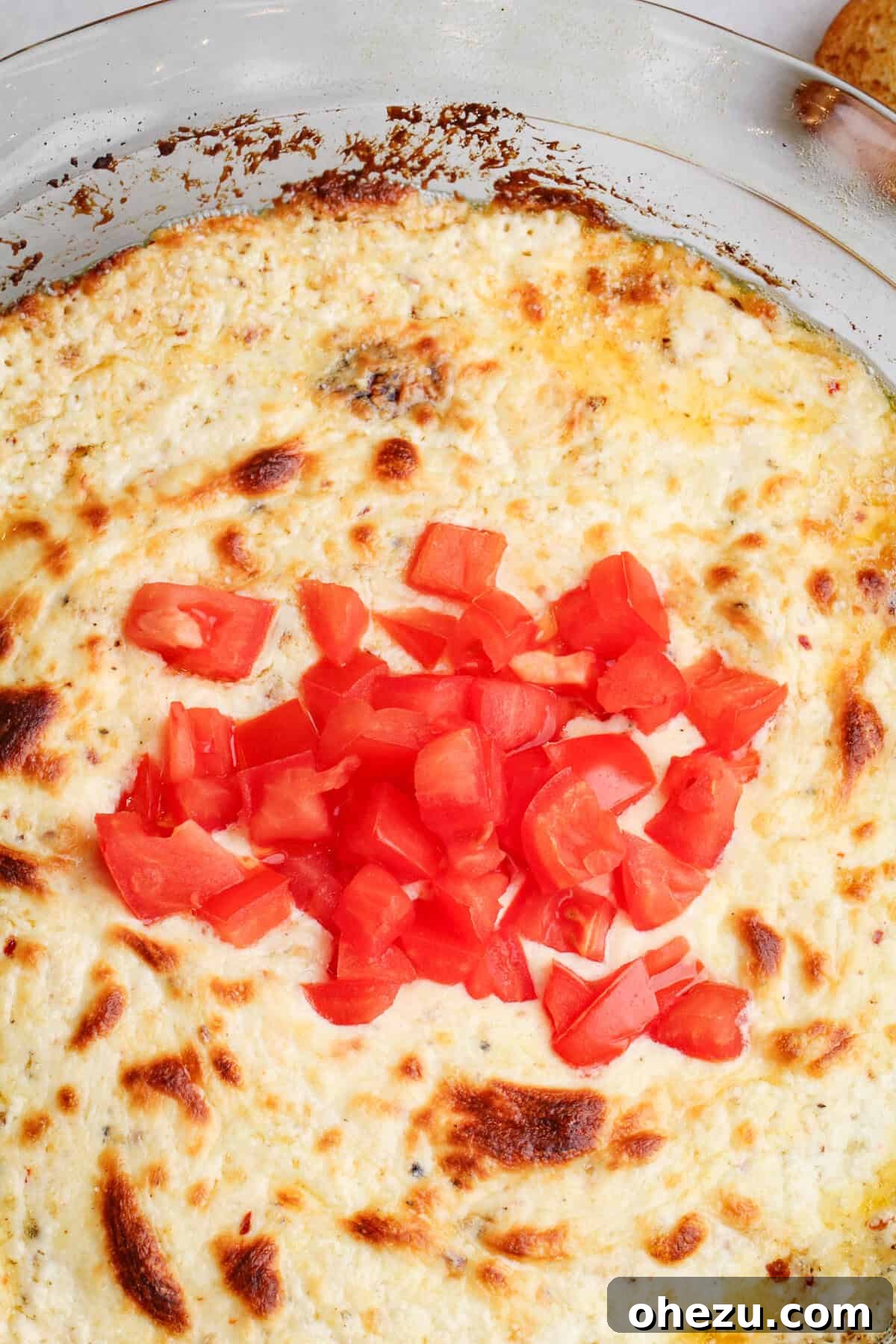 Delicious five-cheese garlic dip bubbling in a baking dish, ready to be served with crusty bread