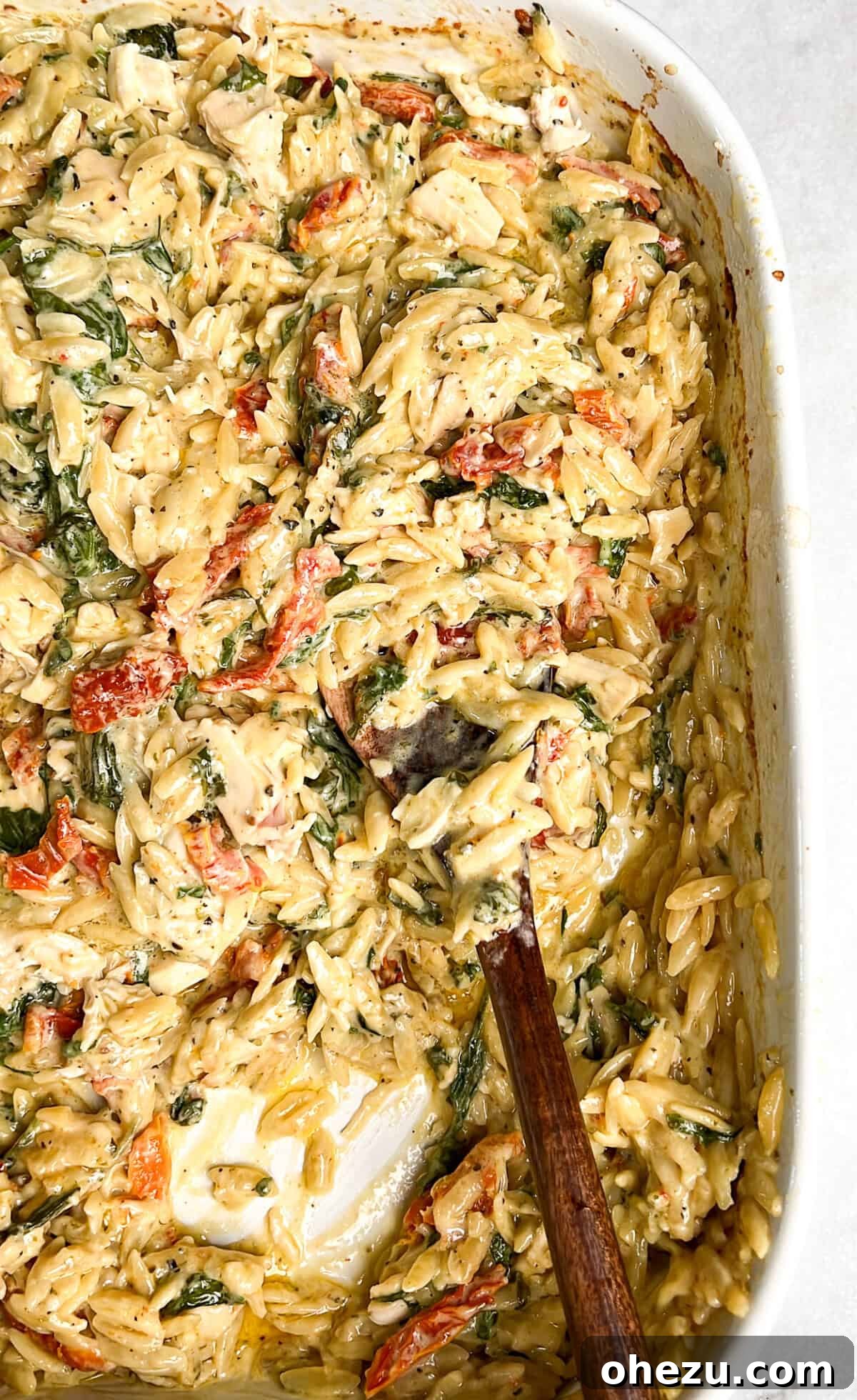 Skillet Chicken Orzo That Wins Hearts 3 A large pan filled with Marry Me Chicken Orzo, rich with sun-dried tomatoes and spinach, resting on a kitchen counter, ready to be served.