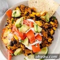 mexican quinoa cassserole topped with sour cream, tomatoes, and avocados