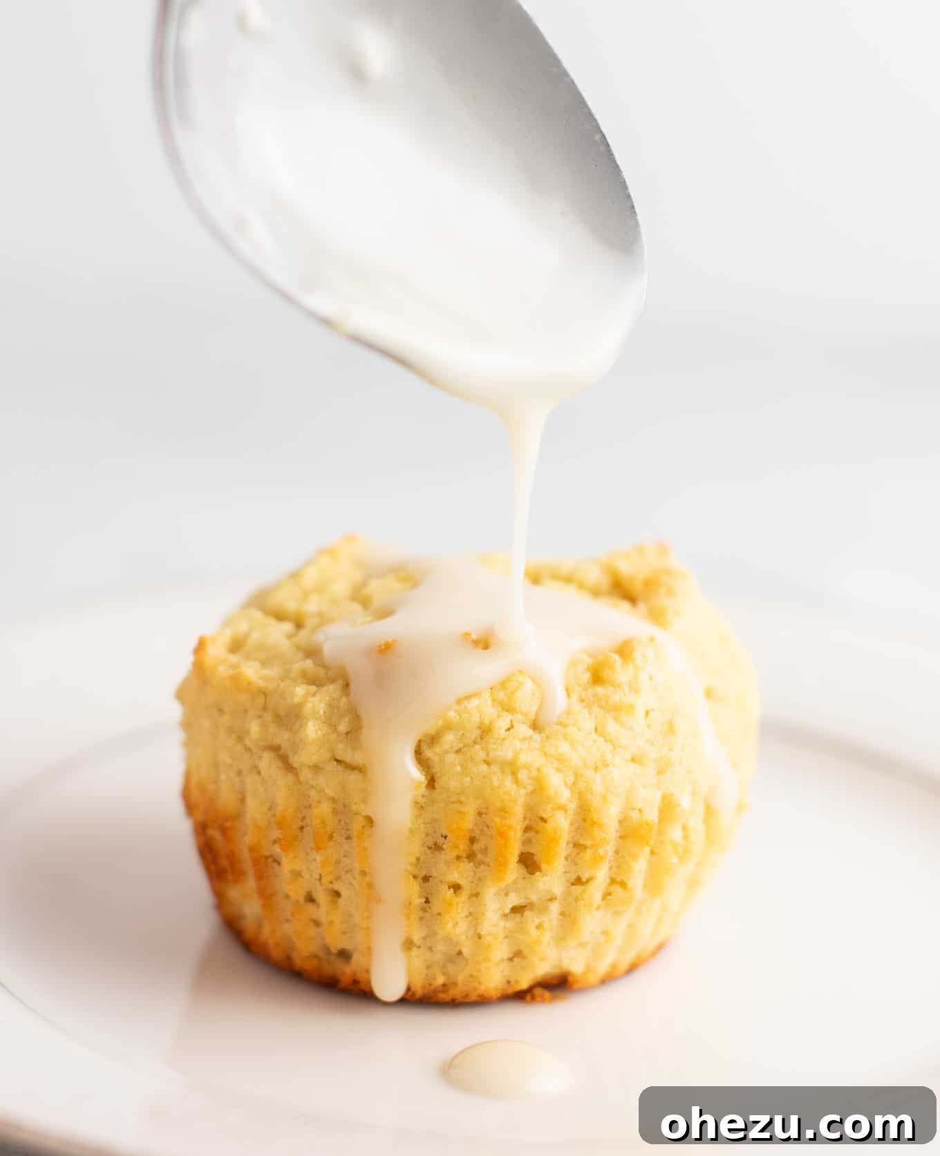 Close-up of fluffy gluten-free muffins topped with a sweet lemon glaze. These muffins maintain their structure and are bursting with fresh lemon flavor, making them a fantastic gluten-free breakfast or snack option.
