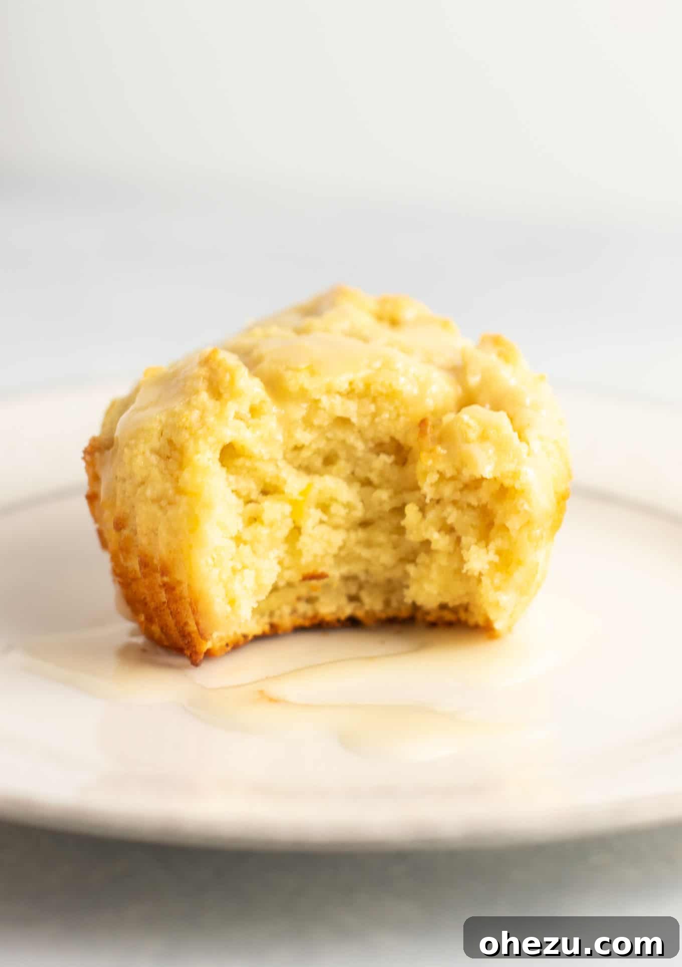Freshly baked gluten-free lemon muffins cooling on a rack, showcasing their fluffy interior before being drizzled with glaze. They hold their shape beautifully, promising a satisfying gluten-free treat.