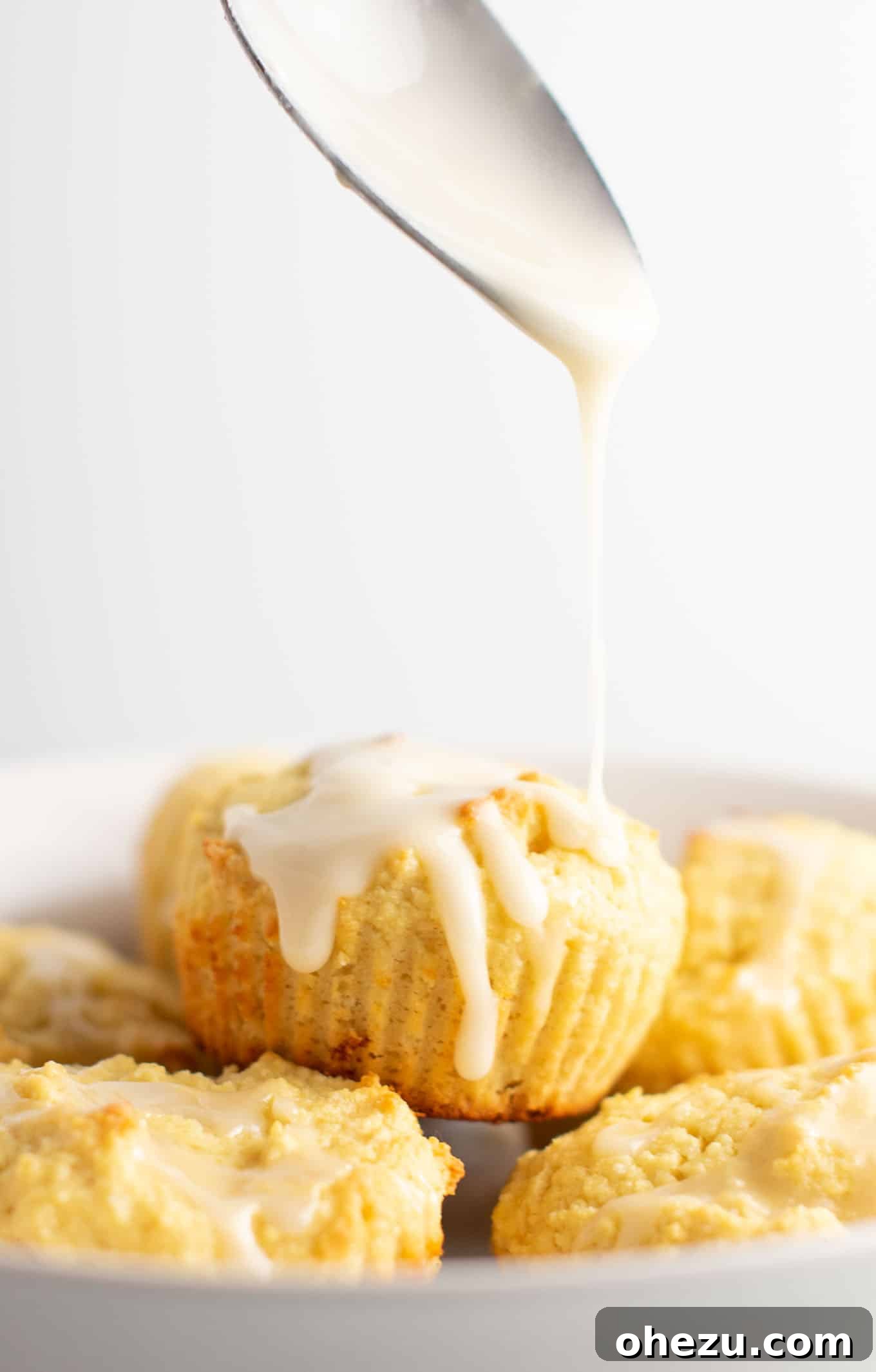 Freshly baked gluten-free lemon muffins cooling, ready for the sweet lemon glaze. They are perfectly risen and golden brown.