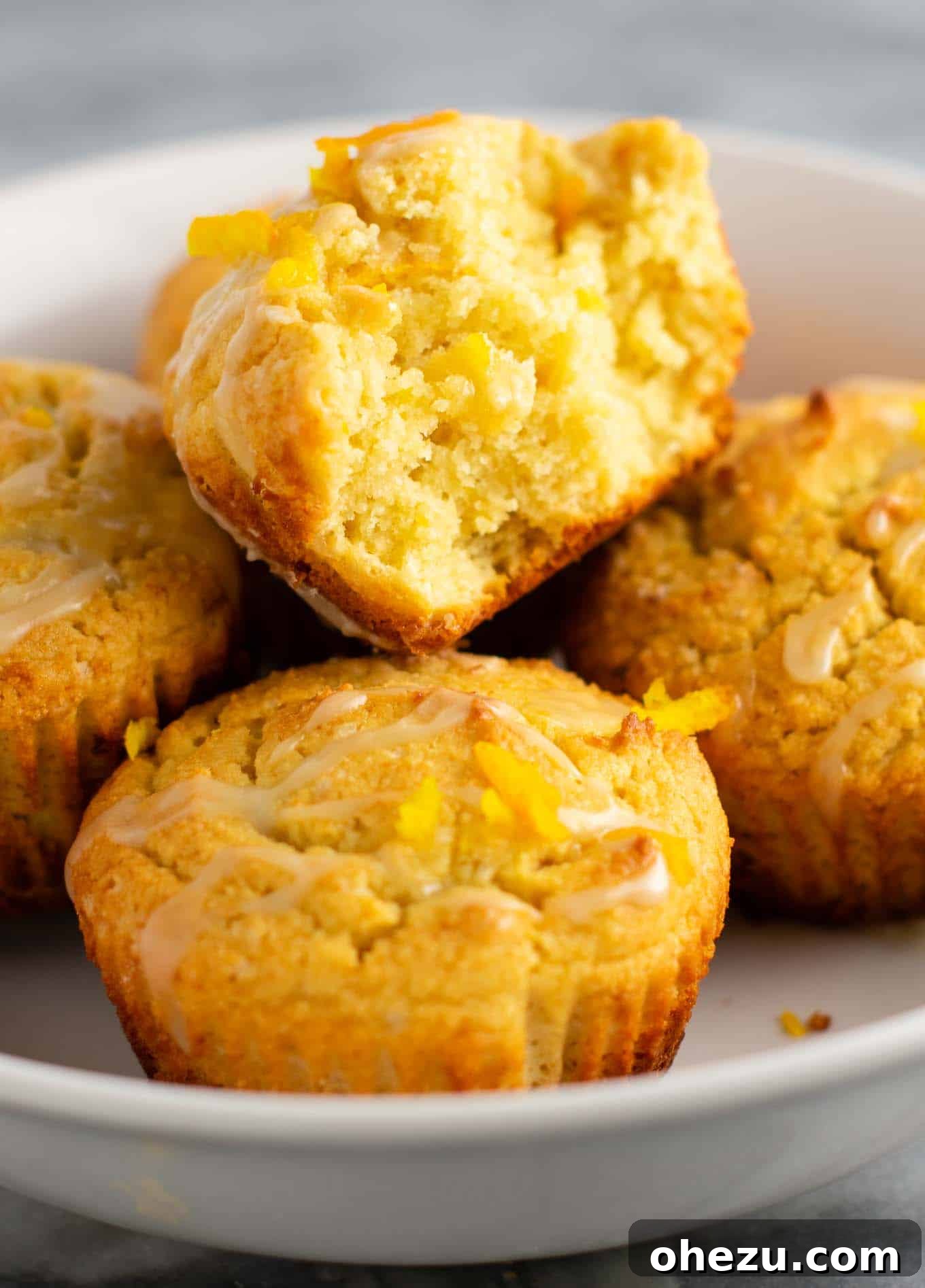 Freshly baked gluten-free orange muffins cooling on a wire rack, ready for glazing
