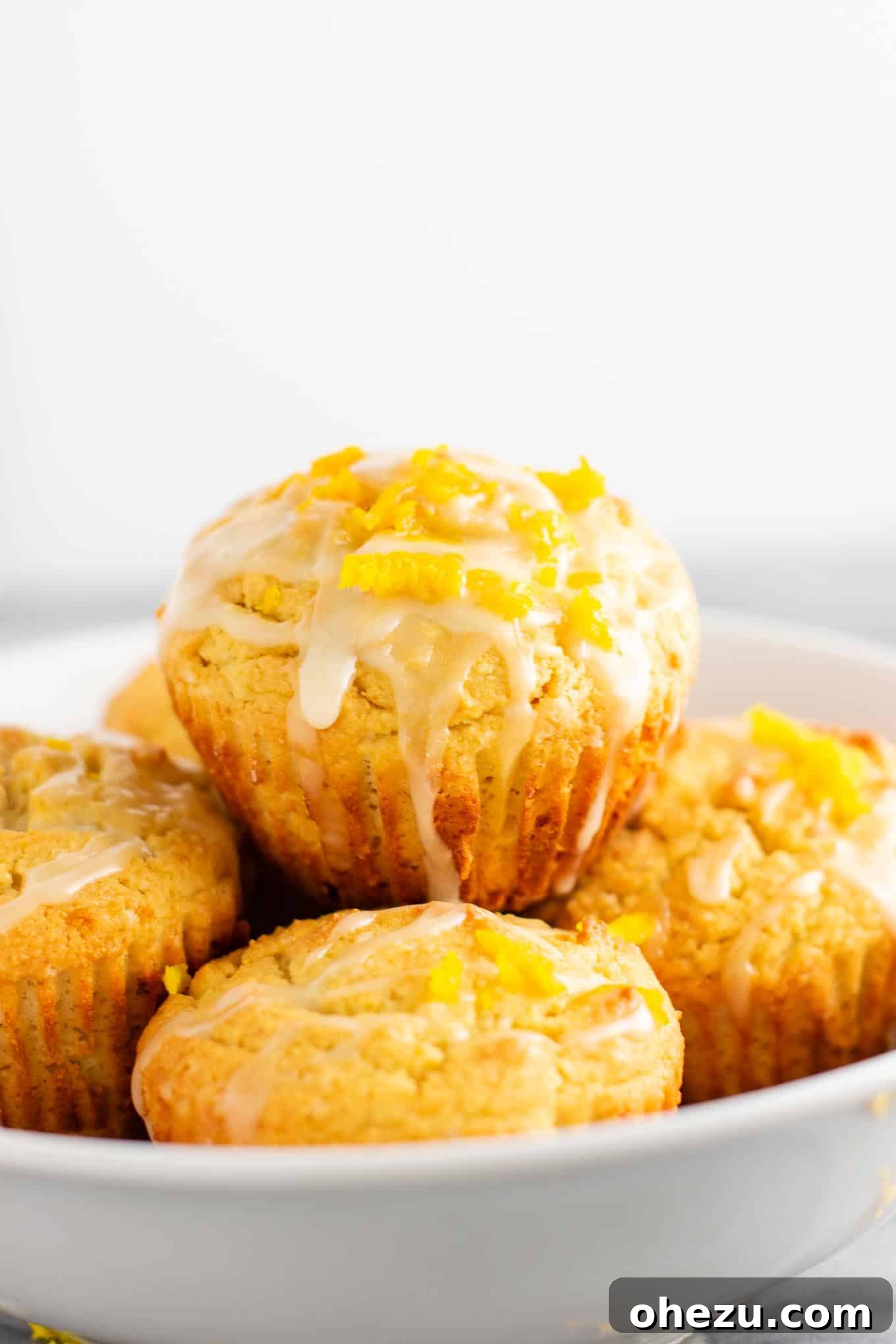 Close-up of a single gluten-free orange muffin with glaze, on a cooling rack