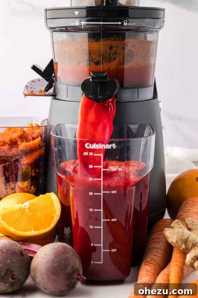 carrot beet juice pouring out of a juicer