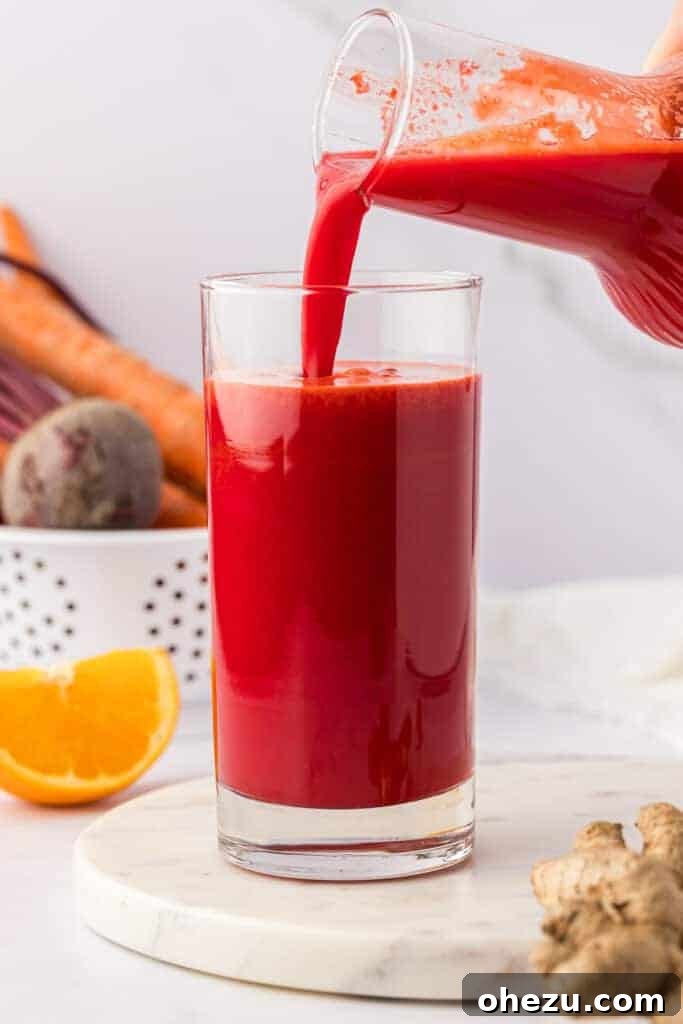 pouring beet and carrot juice into a glass