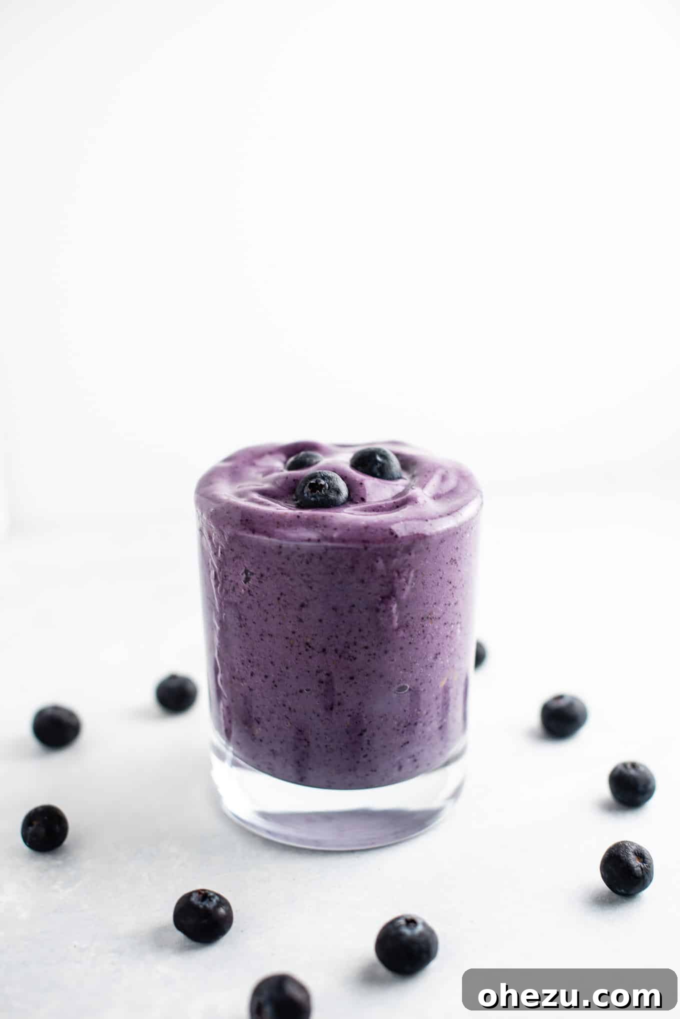 Velvet Berry Banana Smoothie 3 A close-up shot of a thick and delicious blueberry and banana smoothie in a glass, showcasing its vibrant color and creamy texture.