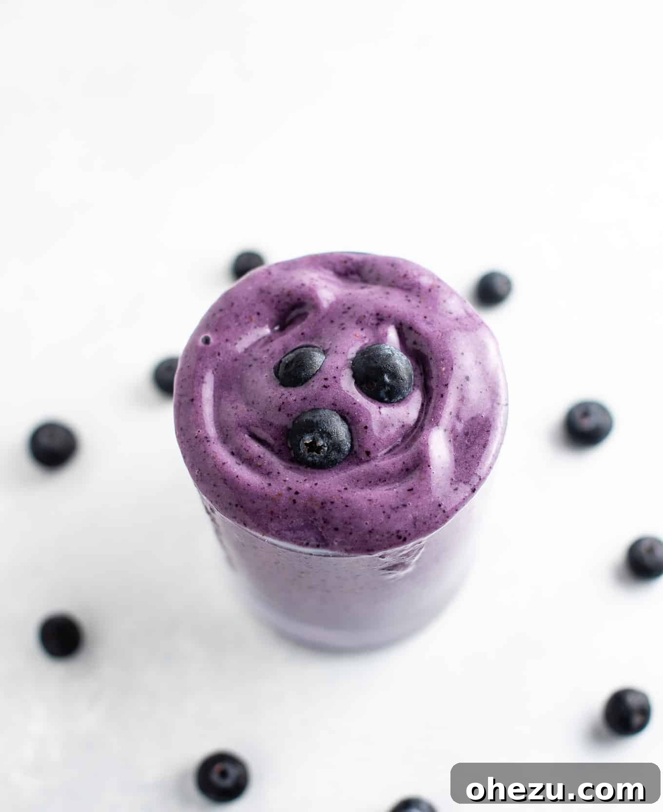 Velvet Berry Banana Smoothie 4 An inviting overhead view of a blueberry smoothie in a glass, with vibrant blue hues and a creamy texture.
