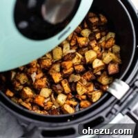Air fryer breakfast hash in an air fryer basket, ready to be served.
